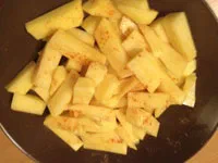 Pommes in einer Schüssel würzen